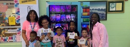 Beanstack Top Readers Pose after getting a book from the book vending machine. 