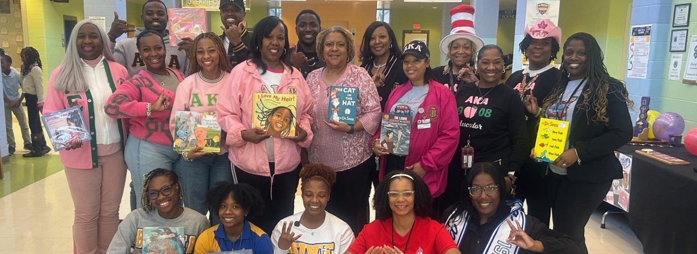 Members of Greek Organizations pose with books they read to students